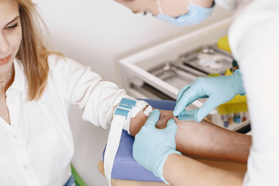 женщина сдает анализ крови из вены в лаборатории