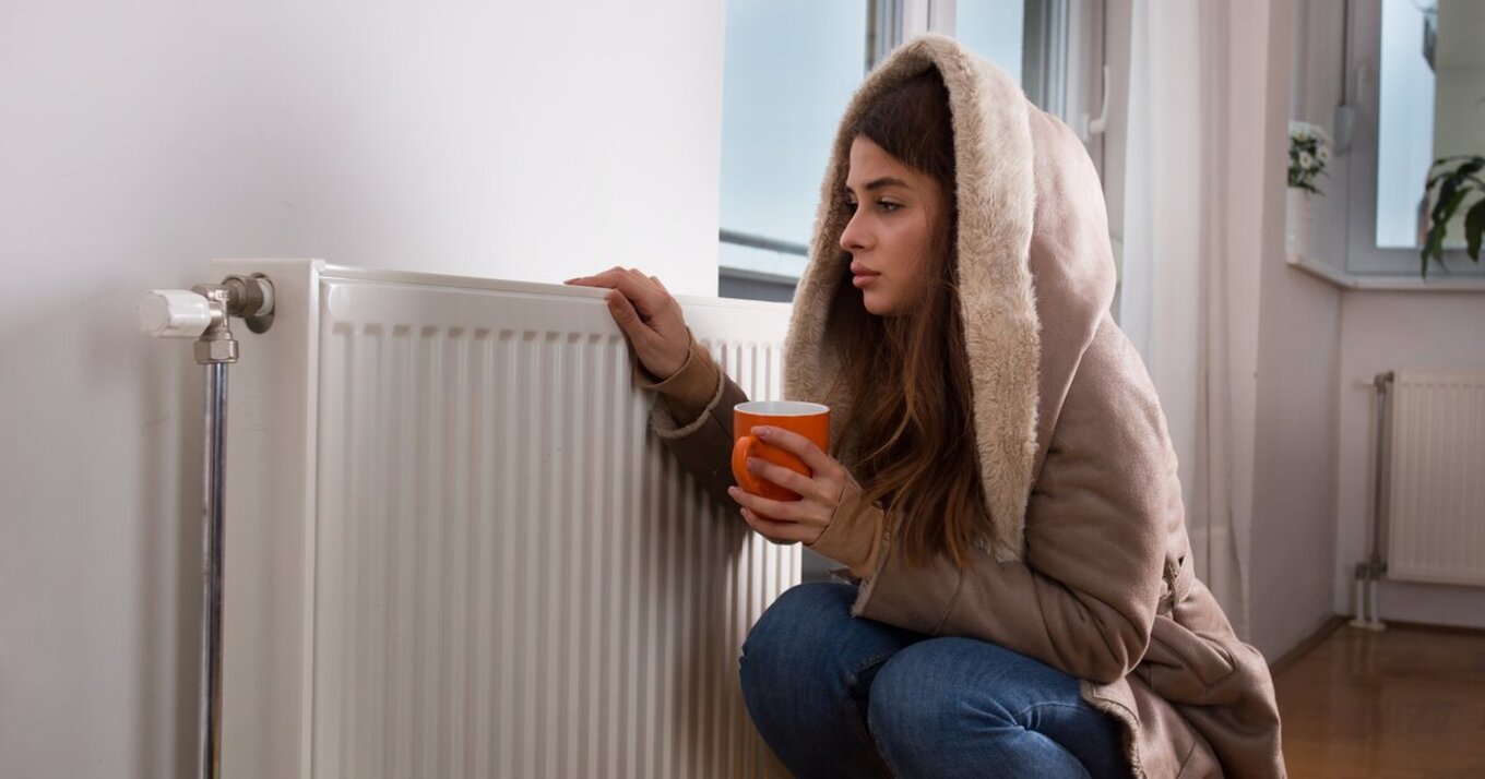 девушка мерзнет - холодная батарея