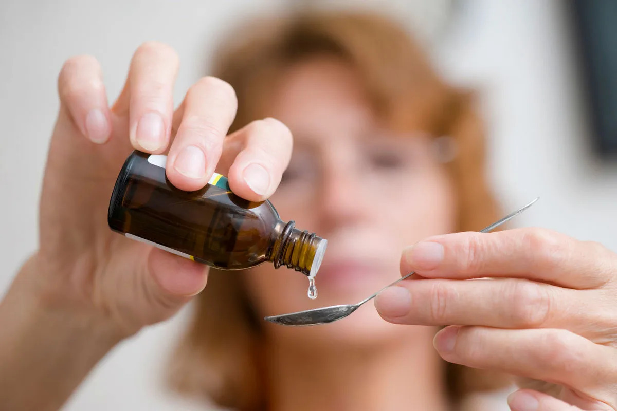 женщина пьет настой валерианы