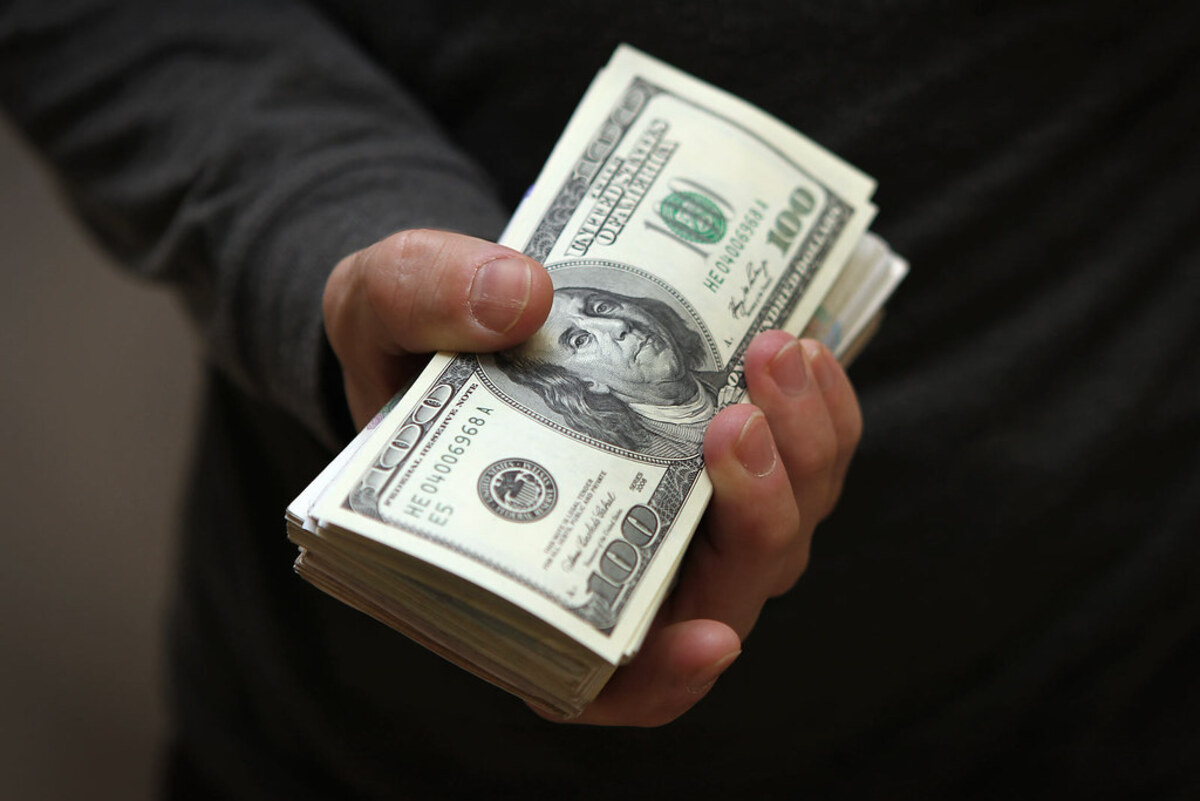 человек протягивает доллары