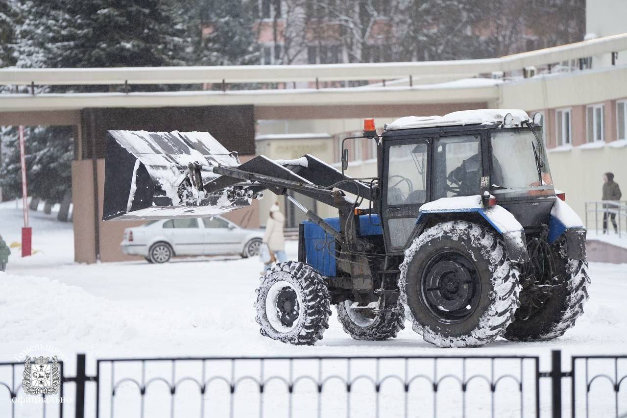 трактор расчищает дорогу от снега