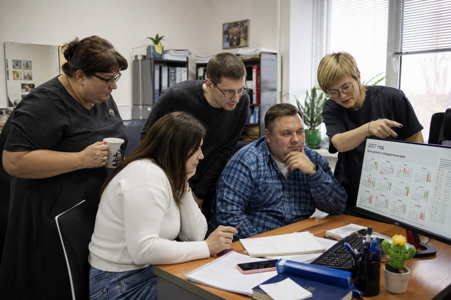 коллеги на работе обсуждают выходные на календаре