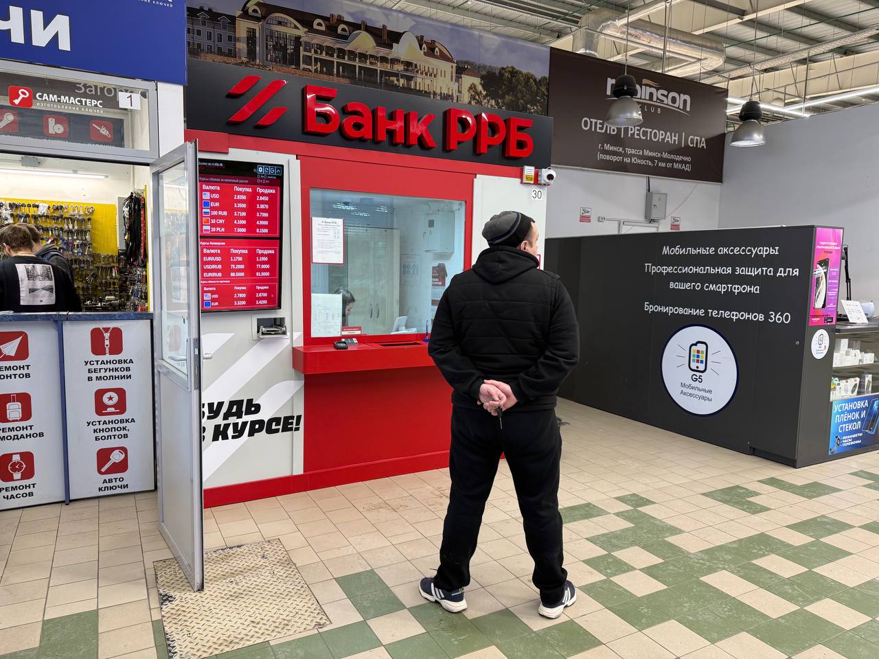 мужчина перед обменным пунктом банка