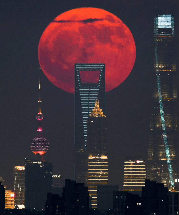 Кровавая Луна восходит за городскими небоскребами