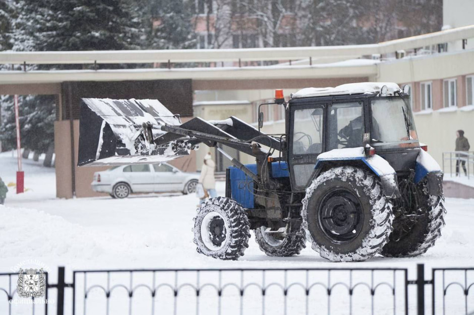 трактор расчищает дорогу от снега