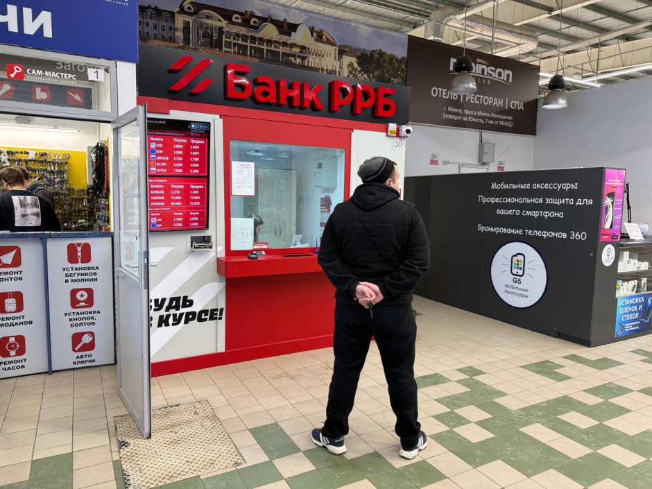 мужчина перед обменным пунктом банка