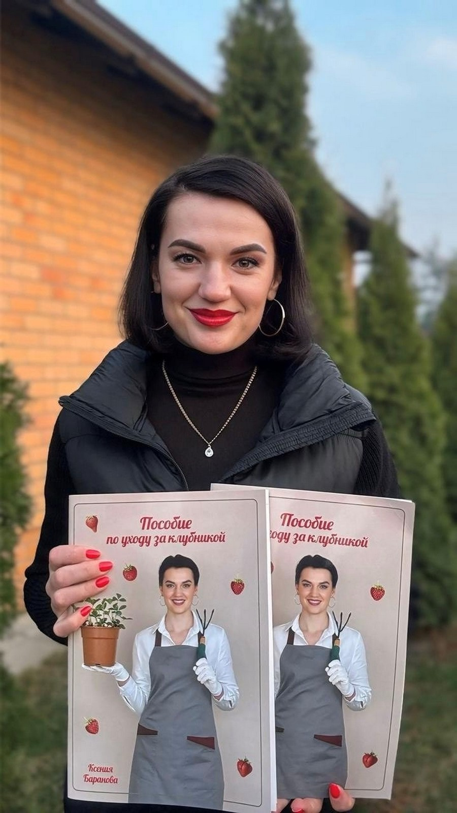11- Ксения Баранова держит в руках свое пособие по выращиванию клубники.jpg