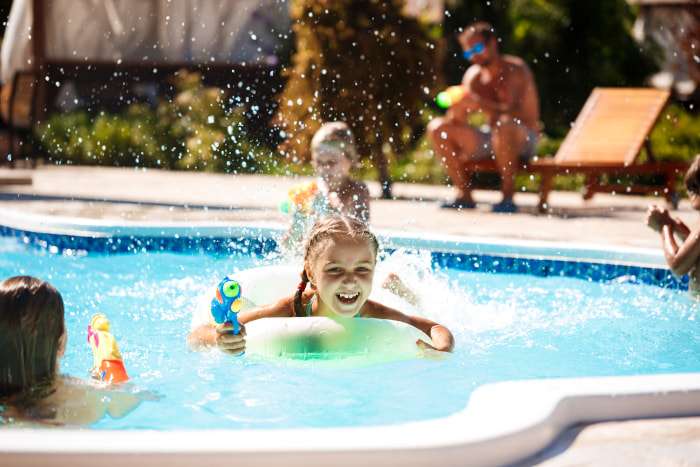 cheerful-children-playing-waterguns-rejoicing-jumping-swimming-pool.jpg
